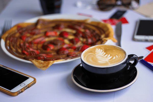 A nutella and strawberry crepe and coffee